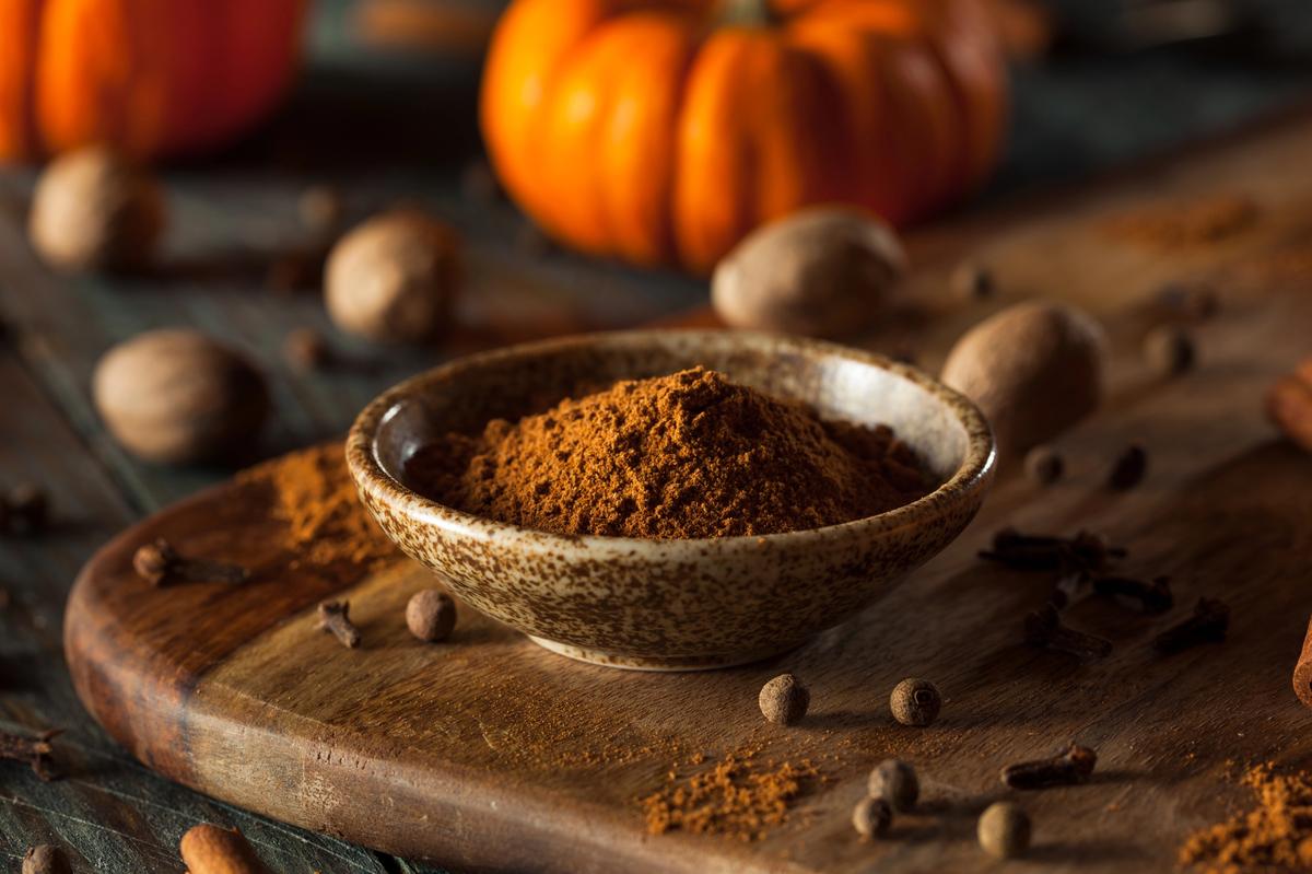 Mélange d'épices pumpkin spice dans un bol, avec noix de muscade, clous de girofle et cannelle.