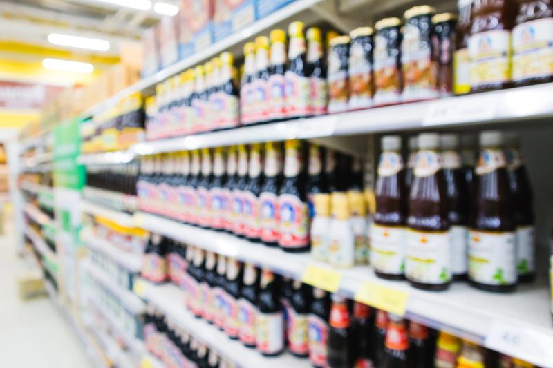 Bouteilles de sauce nuoc mam authentique alignées sur une étagère de supermarché asiatique