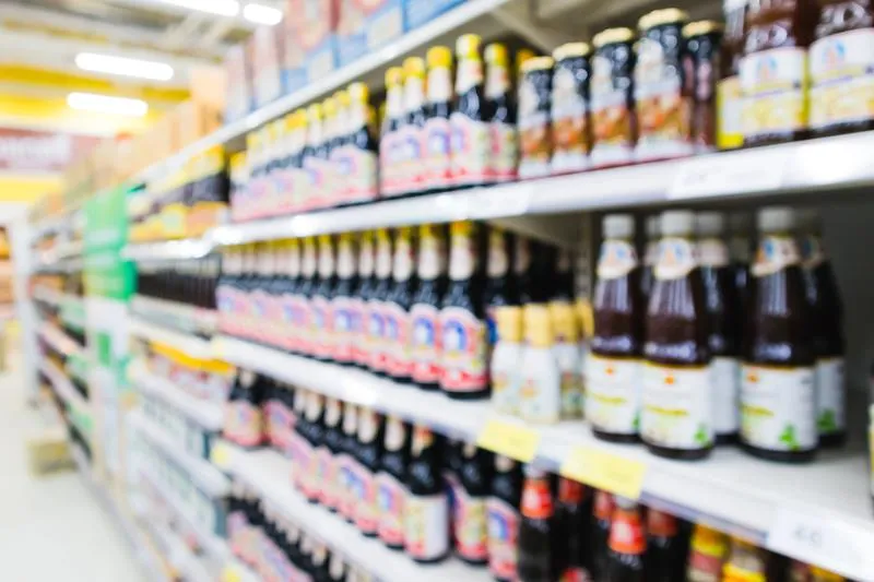 Bouteilles de sauce nuoc mam authentique alignées sur une étagère de supermarché asiatique